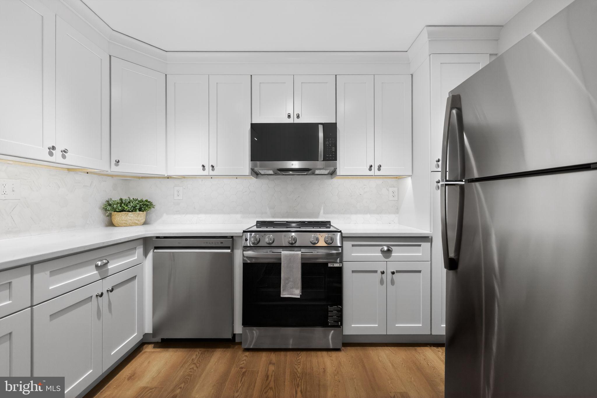 400 Glendale Road, Unit G33 Havertown, PA 19083 - Photo 9 of 26 a kitchen with cabinets stainless steel appliances and wooden floor