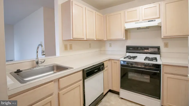 a kitchen with granite countertop white cabinets and white stove