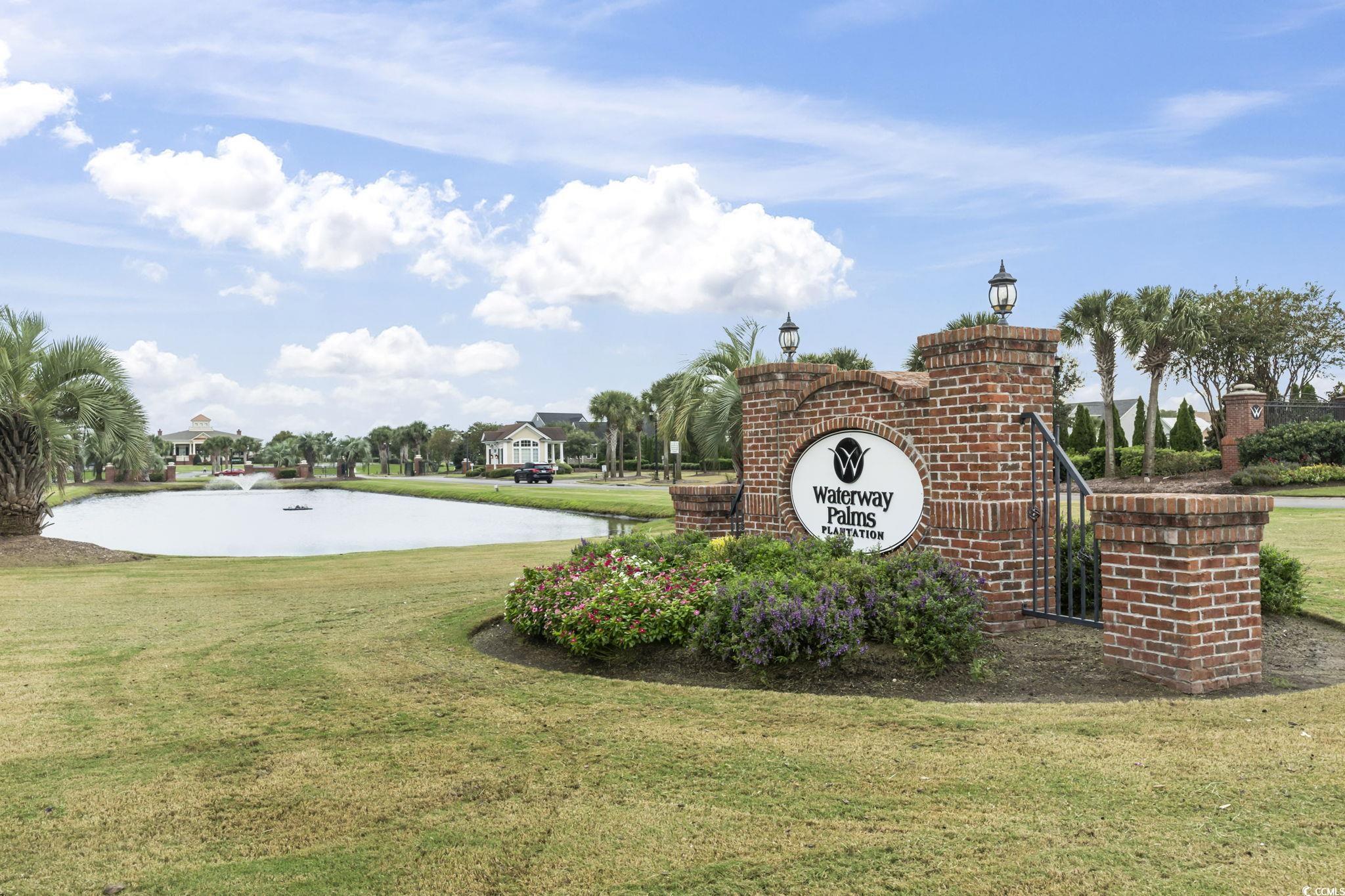 1103 East Isle Of Palms Avenue Myrtle Beach, SC 29579 - Photo 2 of 15 Community sign with a lawn and a water view