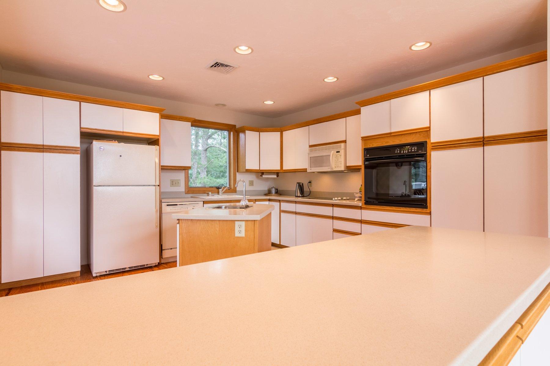 20 South Chatham Road Harwich, MA 02645 - Photo 7 of 35 a kitchen with stainless steel appliances granite countertop a refrigerator a stove and a sink with wooden floor