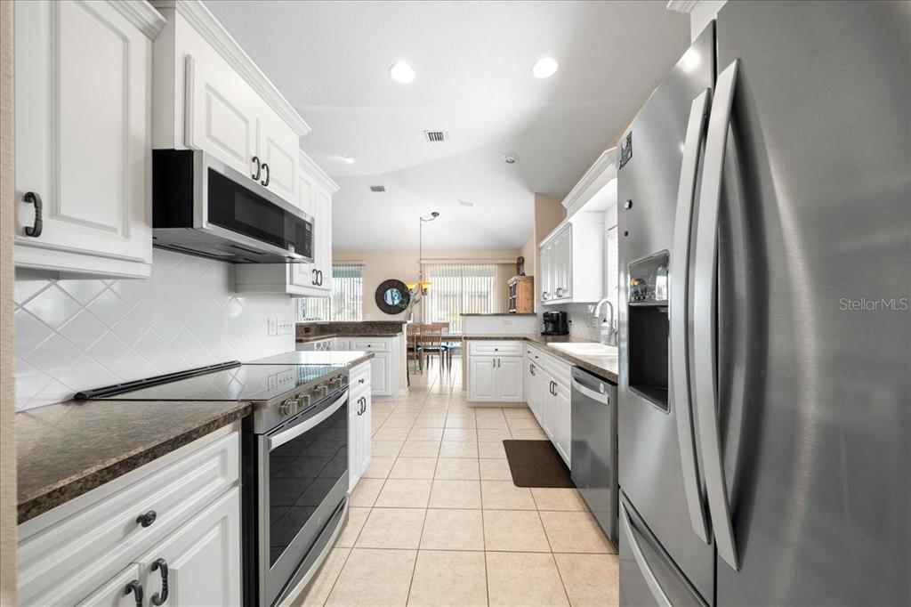 2197 Northwest 55th Avenue Road Ocala, FL 34482 - Photo 51 of 66 a kitchen with stainless steel appliances granite countertop a refrigerator a sink a stove and microwave