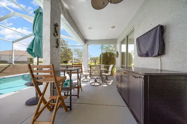 a work room with furniture a large window and glass door