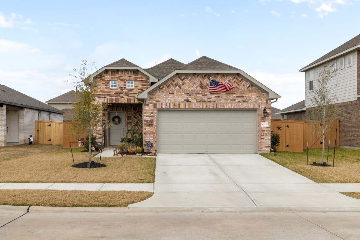 1217 Red Hills Drive Rosharon, TX 77583 - Photo 1 of 25 a view of a white house with large windows next to a road