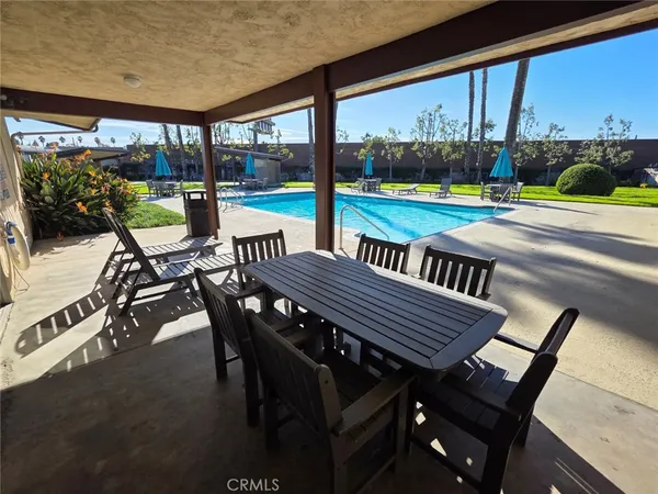 a view of a patio with a table chairs and a backyard