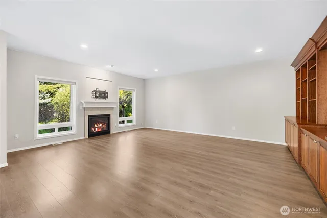 a view of empty room with fireplace and wooden floor