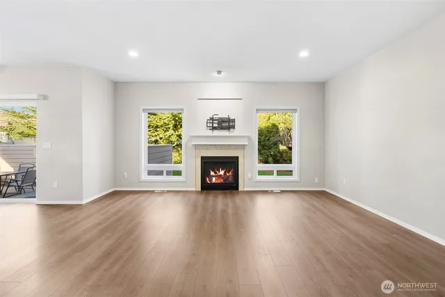 a view of an empty room with a window and fireplace