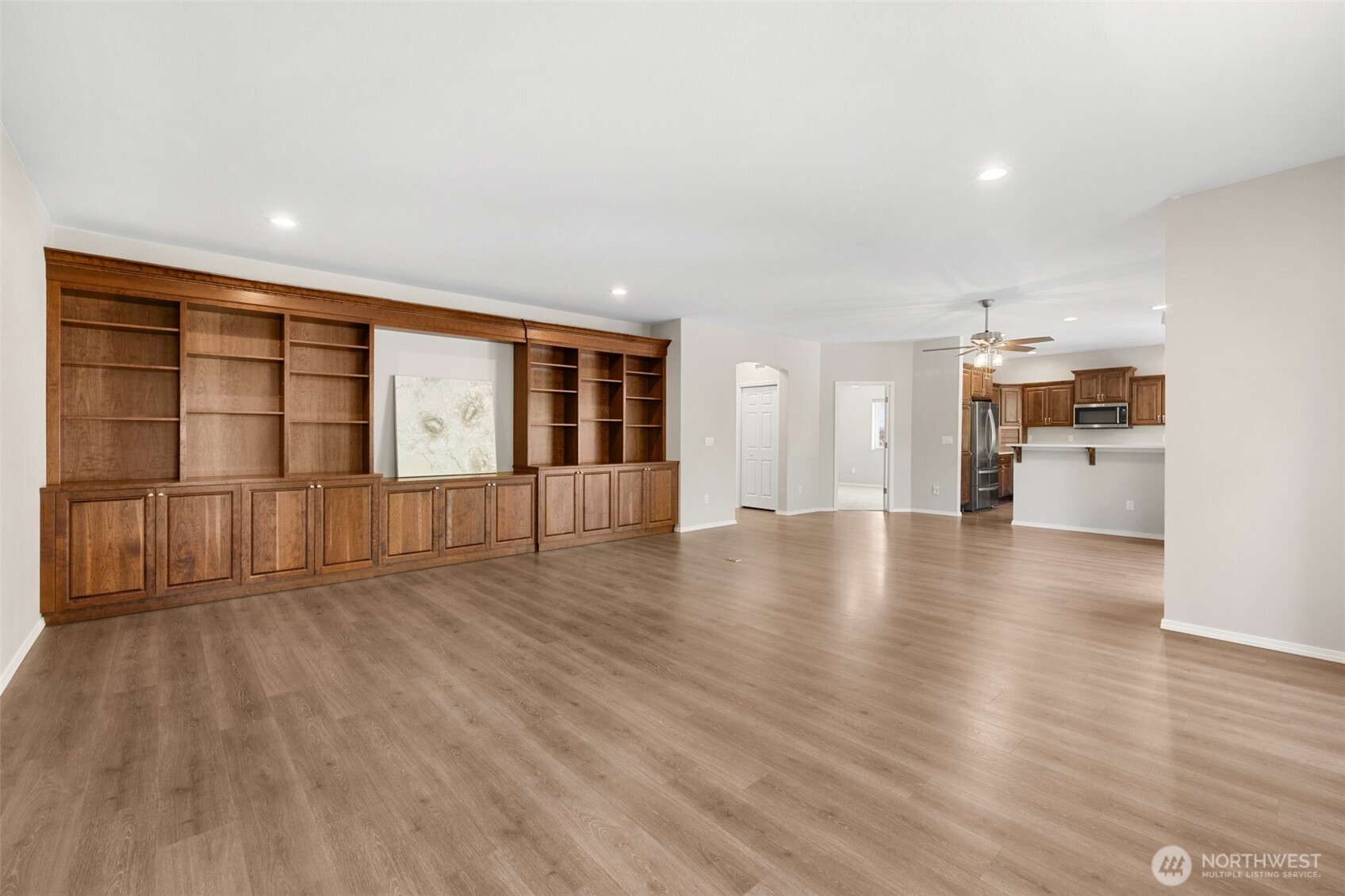 191 Cascadia Loop Sequim, WA 98382 - Photo 24 of 40 a view of an empty room with wooden floor and a kitchen