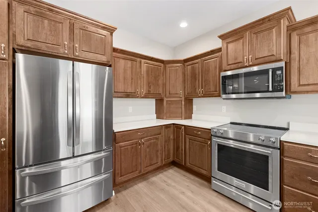 a kitchen with stainless steel appliances granite countertop a refrigerator stove and microwave
