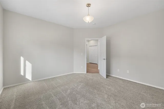 a view of an empty room and a chandelier fan