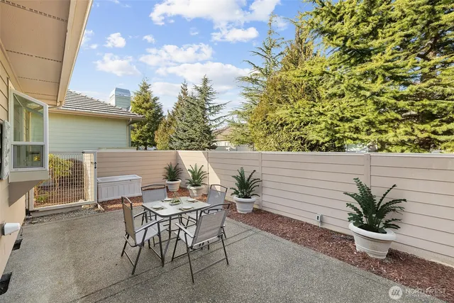 a patio with table and chairs and potted plants