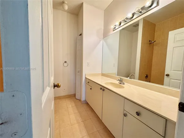 a spacious bathroom with a double vanity sink and mirror with shower