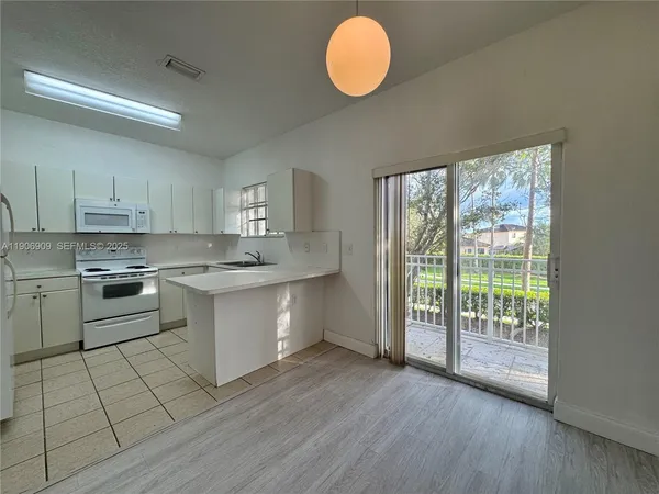a kitchen with a stove a sink and cabinets