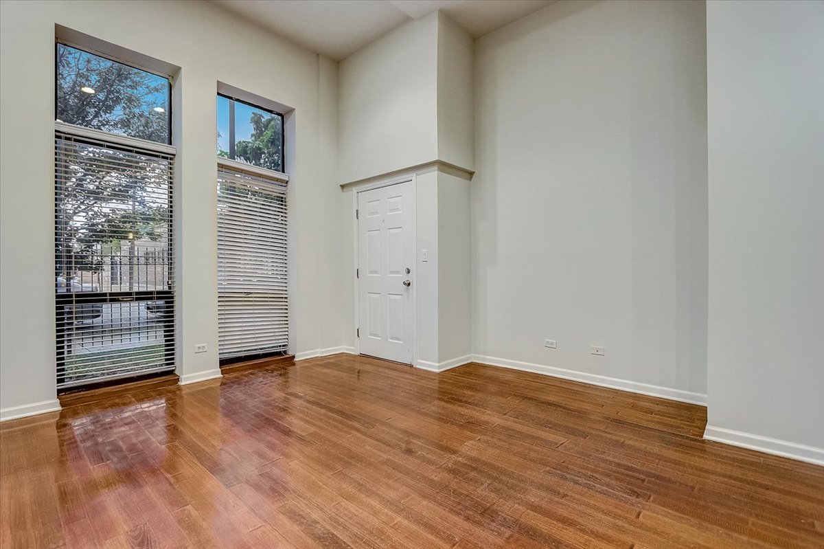 523 North Racine Avenue, Unit 1 Chicago, IL 60642 - Photo 2 of 18 a view of an empty room with wooden floor and windows