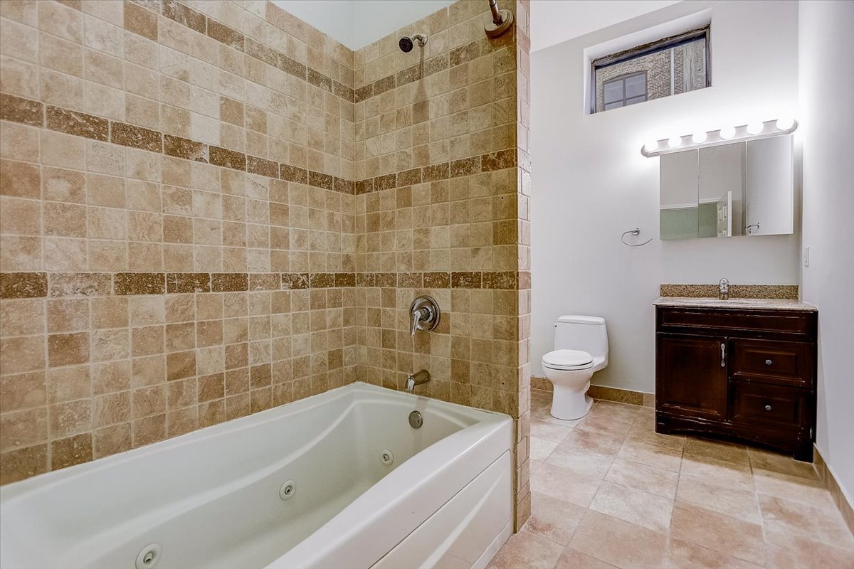 523 North Racine Avenue, Unit 1 Chicago, IL 60642 - Photo 14 of 18 a bathroom with a sink a bathtub and a toilet