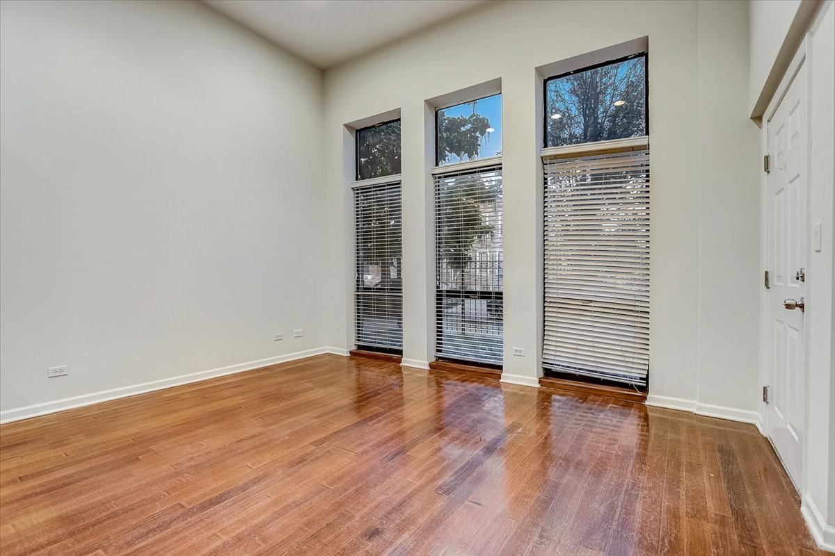 523 North Racine Avenue, Unit 1 Chicago, IL 60642 - Photo 3 of 18 an empty room with wooden floor and windows