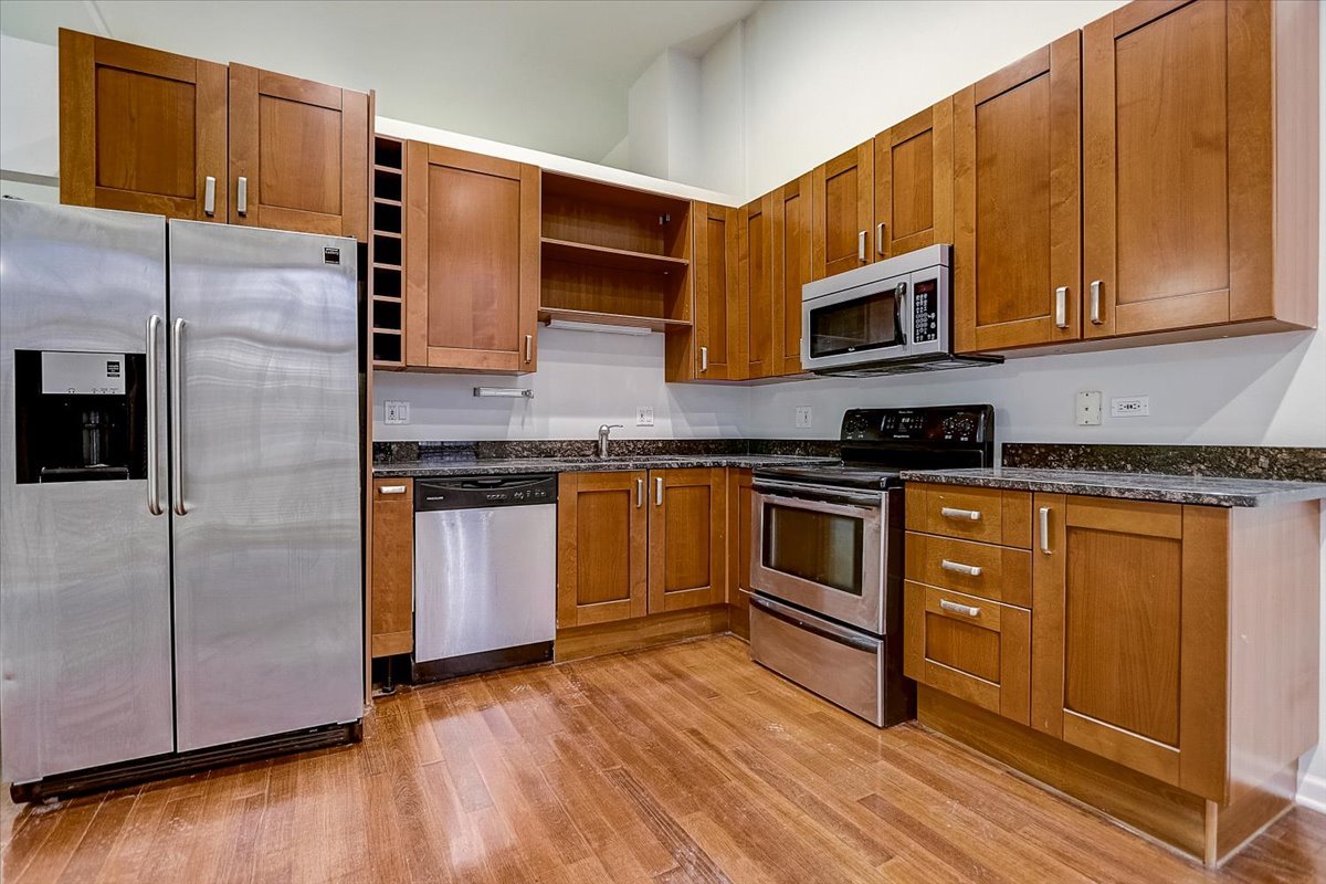 523 North Racine Avenue, Unit 1 Chicago, IL 60642 - Photo 7 of 18 a kitchen with stainless steel appliances granite countertop a stove a sink and a microwave
