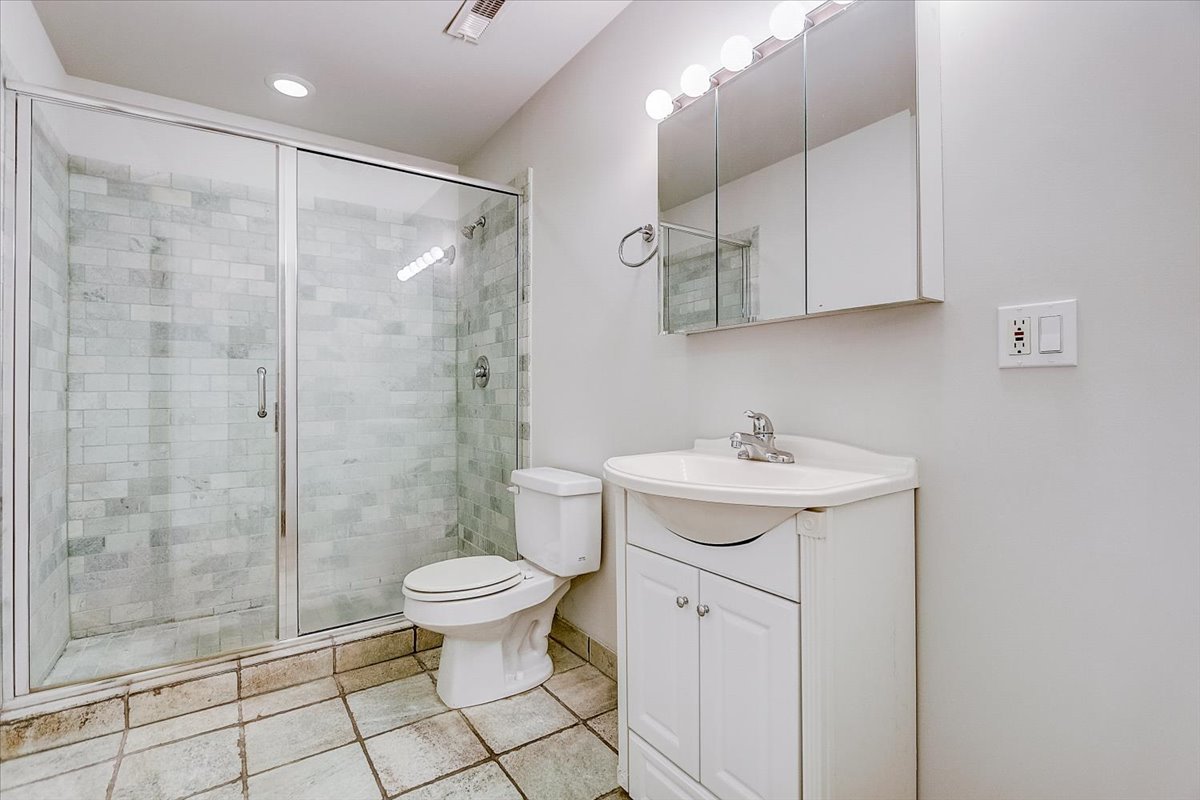 523 North Racine Avenue, Unit 1 Chicago, IL 60642 - Photo 8 of 18 a bathroom with a sink toilet and shower
