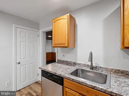 a bathroom with a granite countertop sink and a mirror next to a window