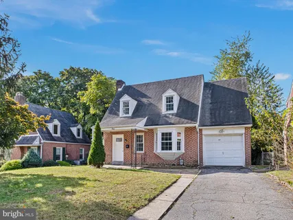 a view of a yard in front of a brick house with large windows