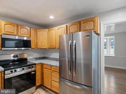 a kitchen with stainless steel appliances granite countertop a refrigerator stove and microwave