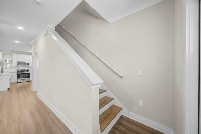 a view of a hallway with wooden floor and staircase