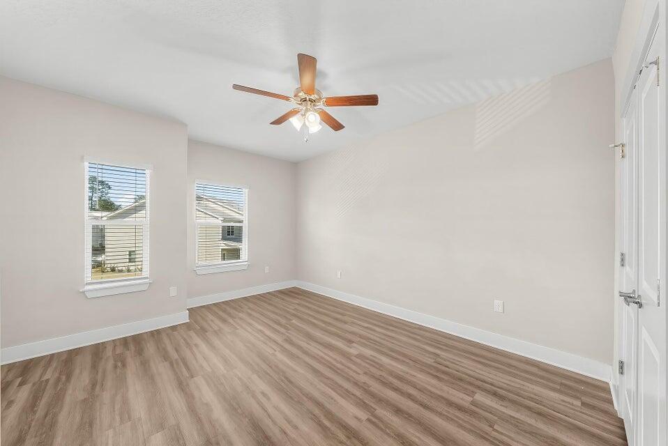 289 North Sand Palm Road, Unit VISTA Freeport, FL 32439 - Photo 22 of 34 an empty room with wooden floor fan and windows