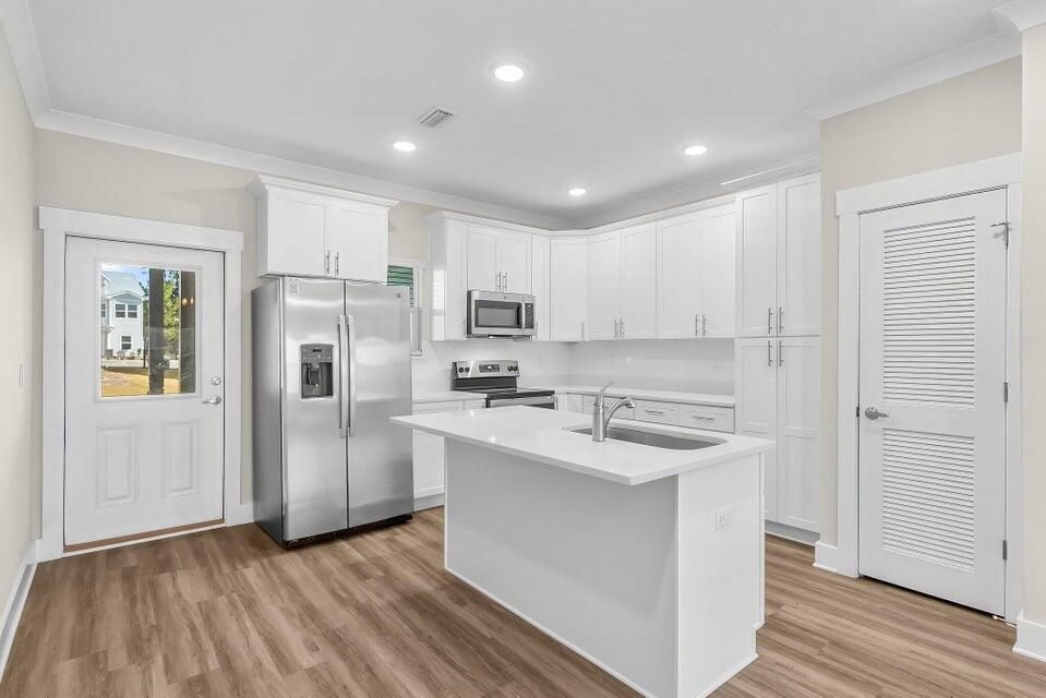 289 North Sand Palm Road, Unit VISTA Freeport, FL 32439 - Photo 3 of 34 a kitchen with stainless steel appliances granite countertop a refrigerator a stove and a sink with wooden floor