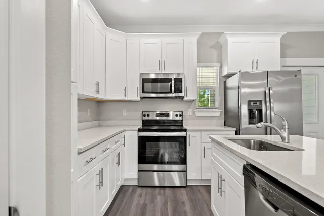 a kitchen with stainless steel appliances granite countertop a stove a sink and a refrigerator