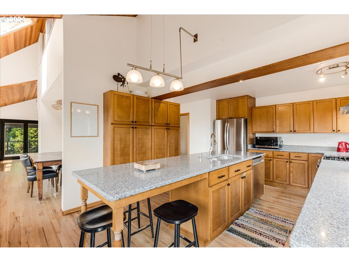 1500 Southwest Walters Drive Gresham, OR 97080 - Photo 5 of 48 a kitchen with stainless steel appliances kitchen island granite countertop a table chairs and a wooden cabinets