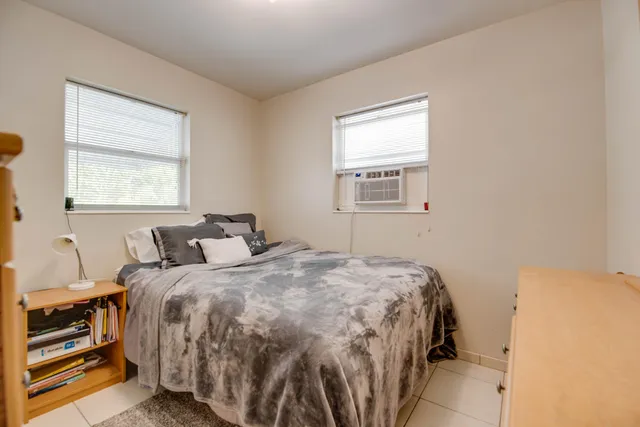 a bedroom with a bed and two windows