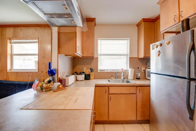 a kitchen with a refrigerator a sink and dishwasher with wooden floor