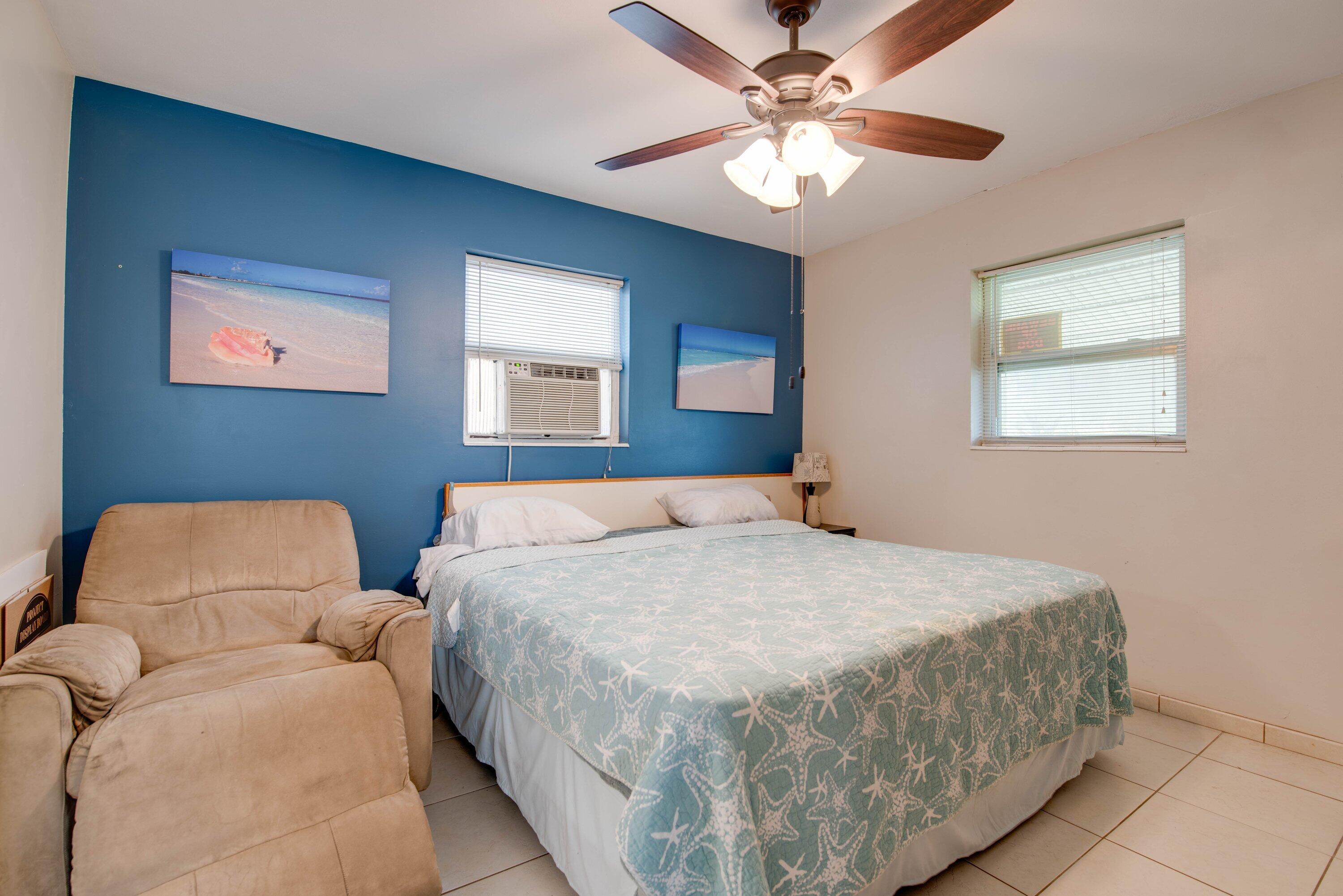317 Cross Street Stock Island, FL 33040 - Photo 20 of 25 a bedroom with a bed chandelier and a window