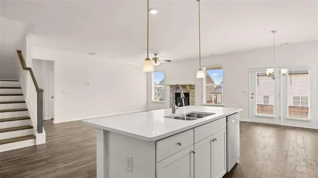 a kitchen with white cabinets and sink