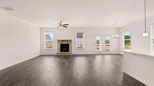 a view of an empty room with wooden floor and a fireplace