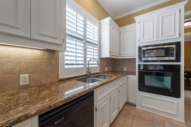 a kitchen with granite countertop a stove sink and cabinets