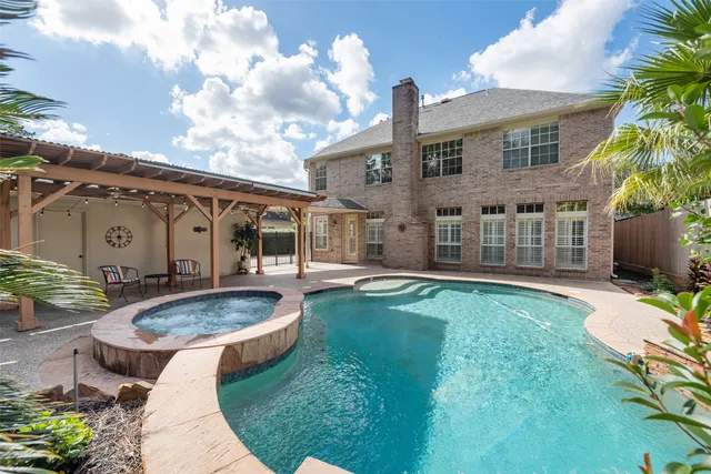 a view of a house with swimming pool and sitting area
