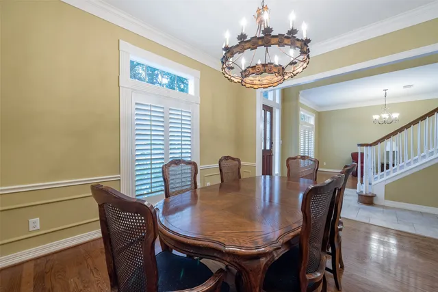 a view of a dining room with furniture a chandelier and wooden floor