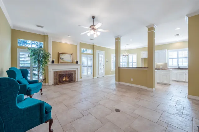 a view of a livingroom with a fireplace a chandelier and windows