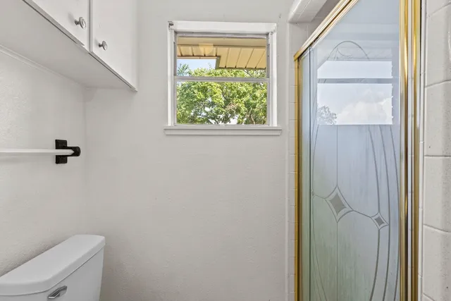a bathroom with a toilet and a shower