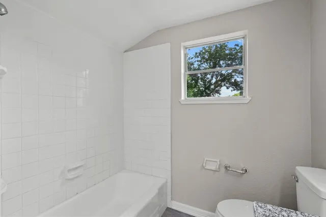 a white toilet sitting next to a bath tub