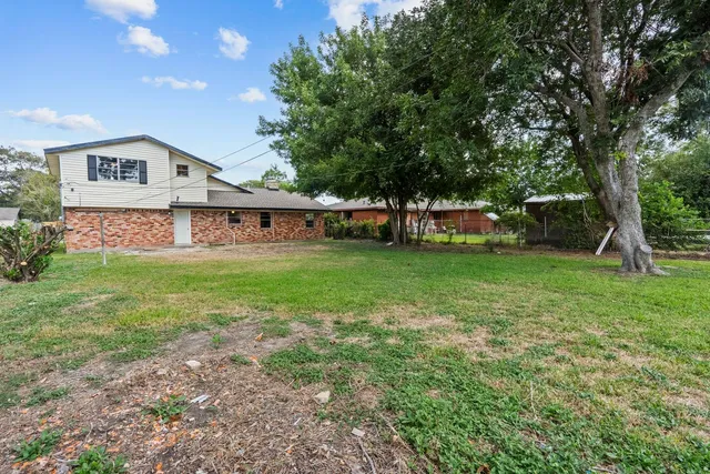 a view of a house with a yard and sitting area