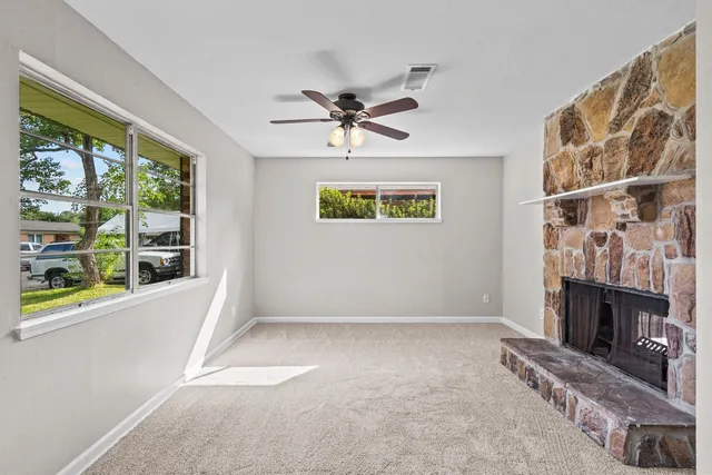 a view of an empty room with a fireplace and a window