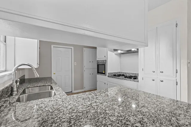 a kitchen with stainless steel appliances granite countertop a refrigerator and a stove top oven