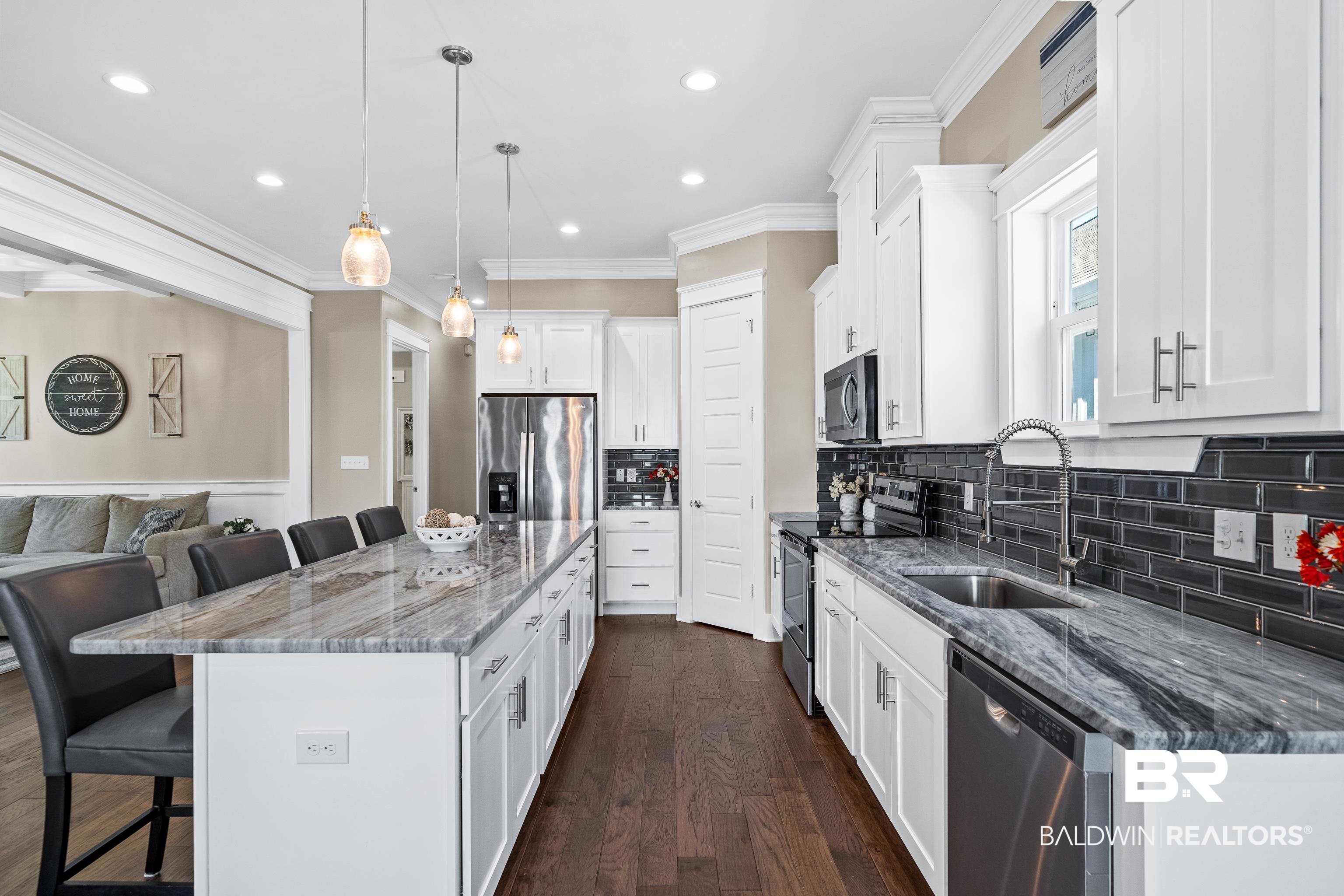 1018 Snapdragon Lane Foley, AL 36535 - Photo 14 of 37 Kitchen featuring a kitchen bar, appliances with stainless steel finishes, sink, decorative light fixtures, and a kitchen island