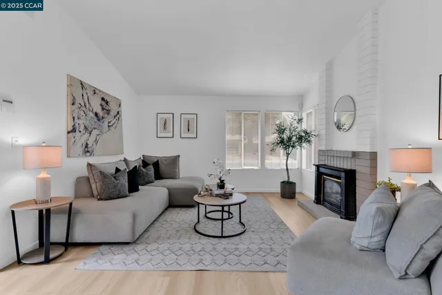 a living room with furniture a fireplace and a table