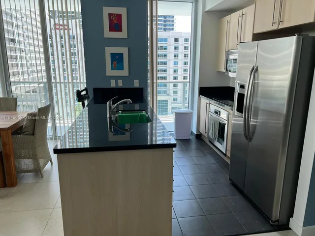 a kitchen with granite countertop a refrigerator and a stove