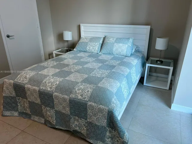 a large bed sitting in a bedroom next to a window