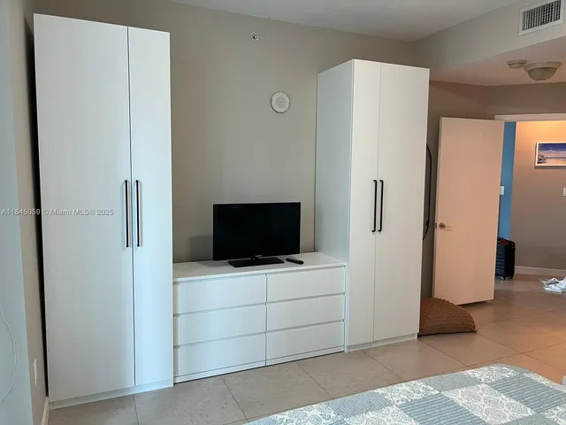 a living room with a flat screen tv and a refrigerator
