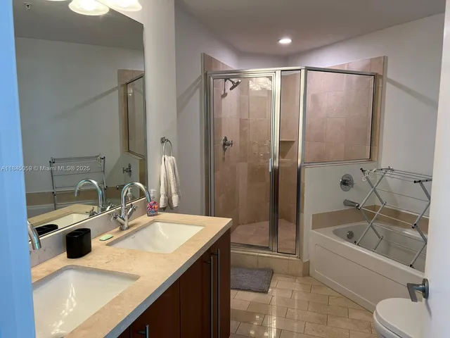 a bathroom with a granite countertop sink mirror and bathtub