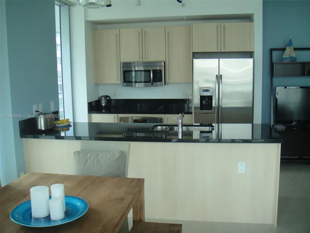 a kitchen with kitchen island a sink and a refrigerator